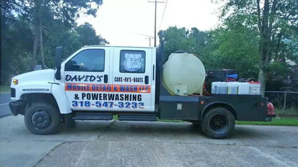 A branded service truck parked at a curb, phone number and bulldog logo on the door